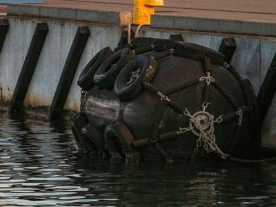 Fenders protecting naval vessel against pier