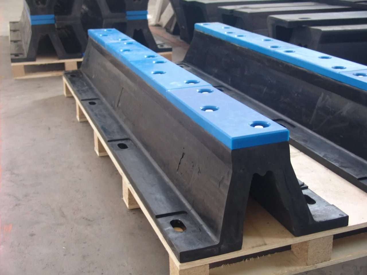 Arch rubber fenders with fitted facing pads in a workshop