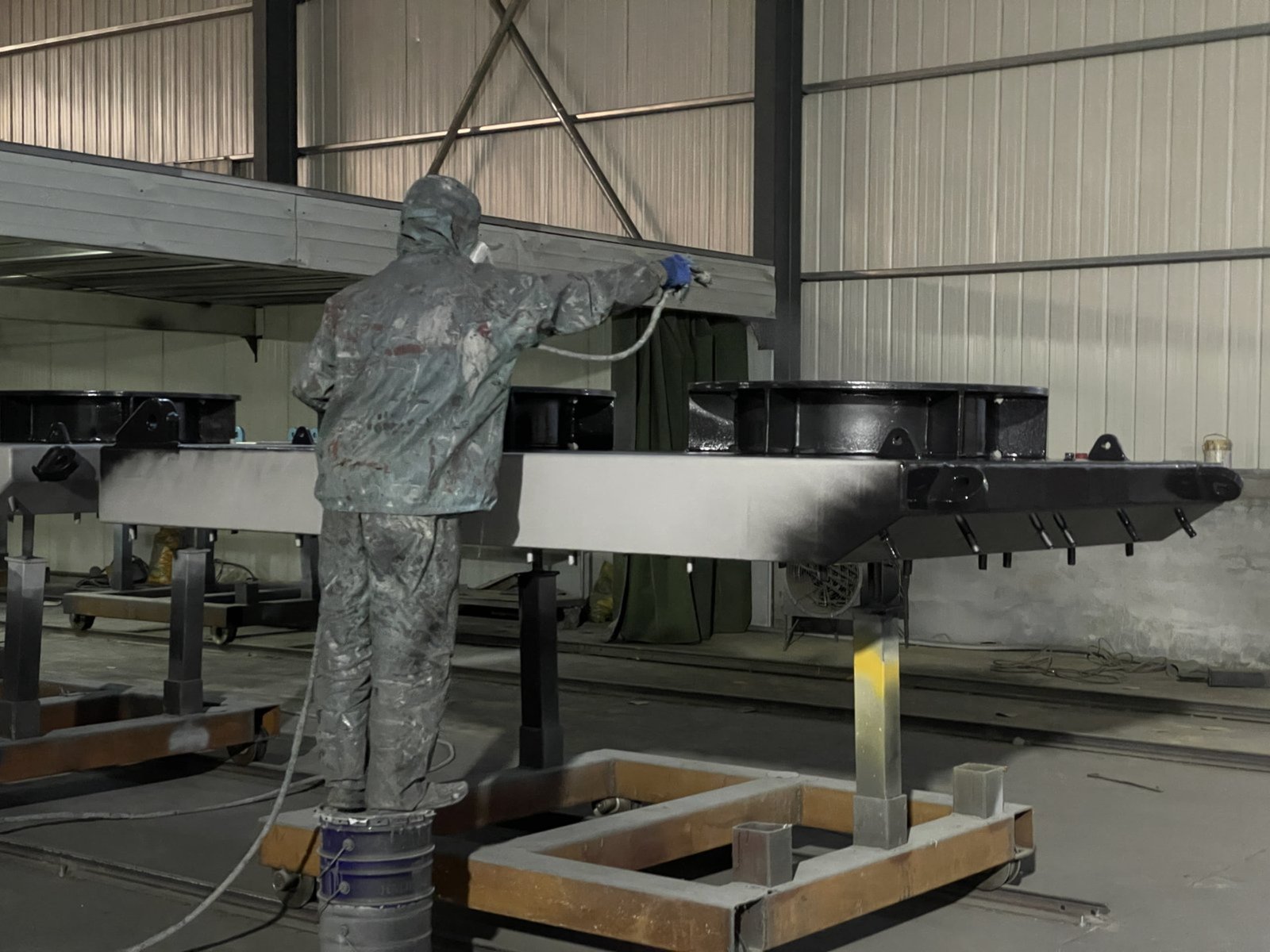 Steel fender panel during protective painting in a workshop