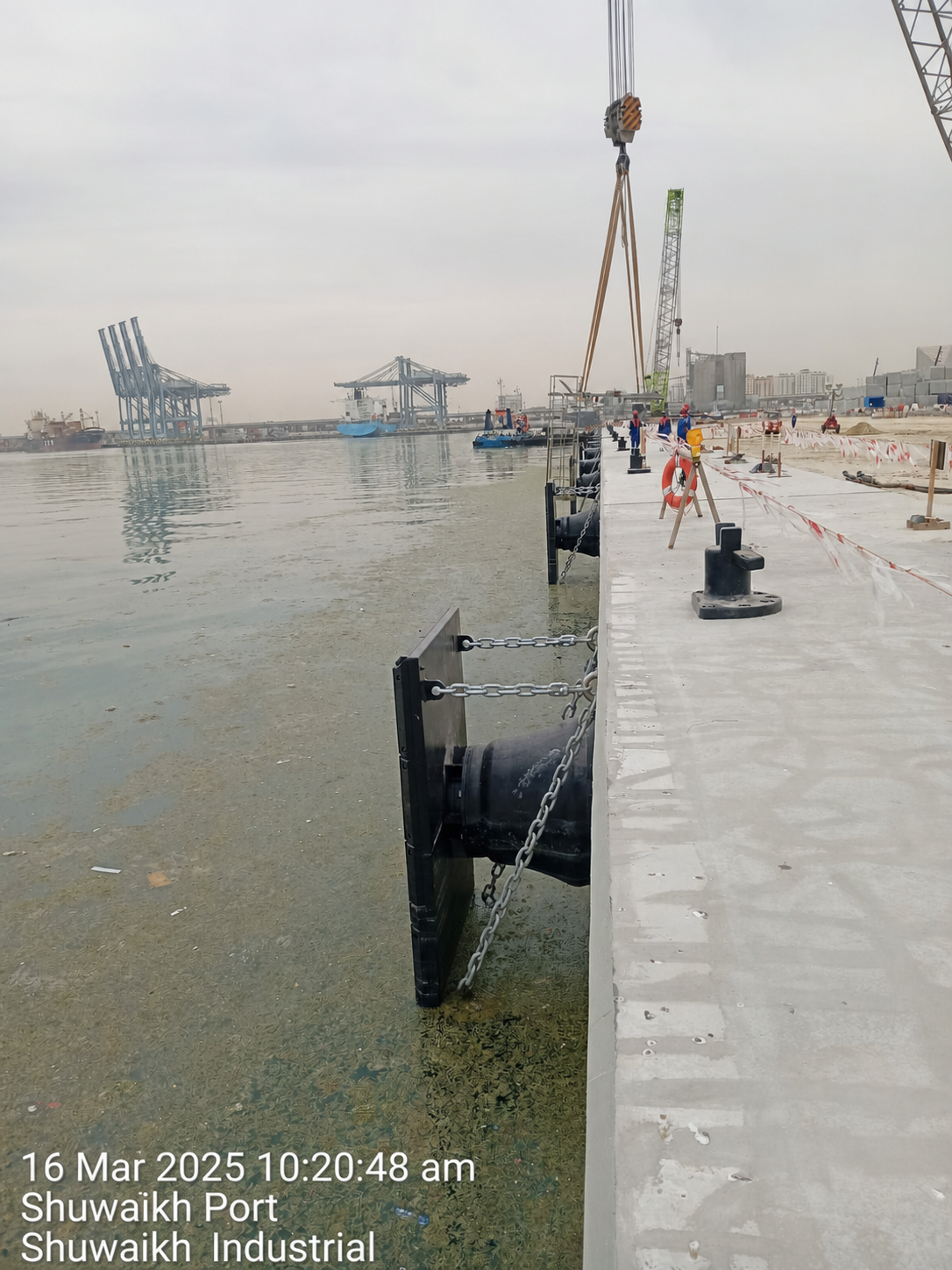 Installed cone rubber fender system with frontal panels and chains on a quay