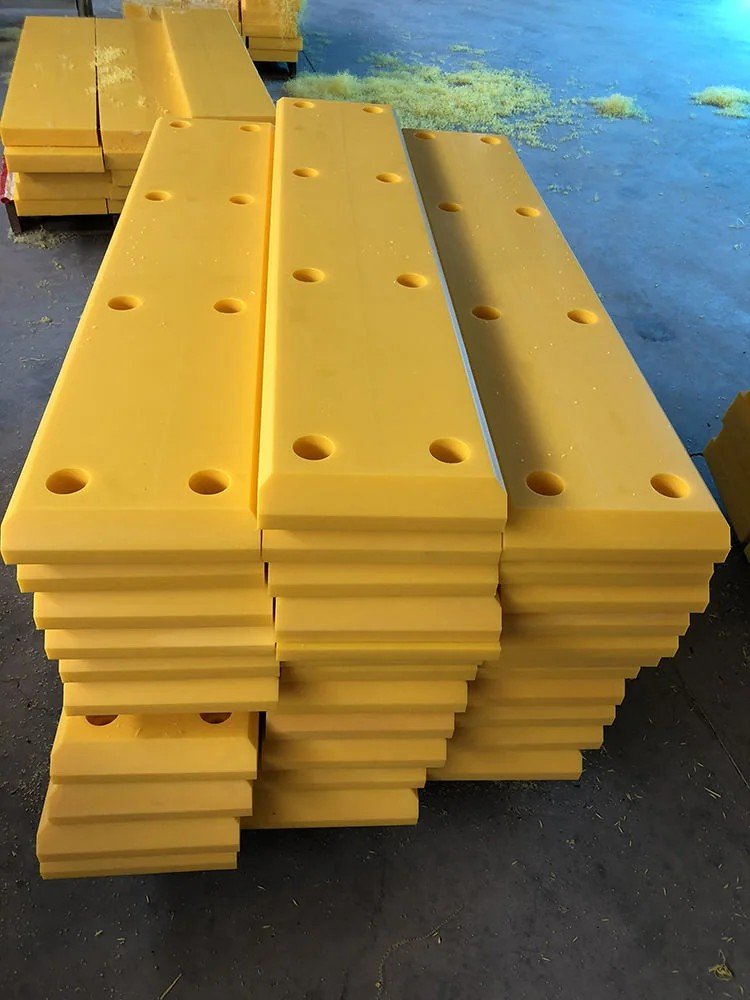Stacked yellow UHMW-PE facing pads with fixing holes