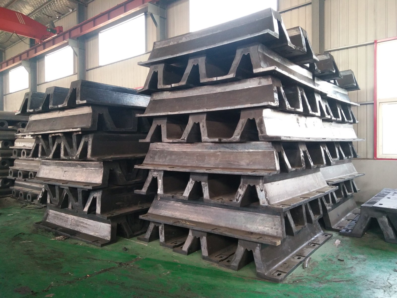 Stacks of uninstalled black molded arch rubber fender bodies inside a workshop environment