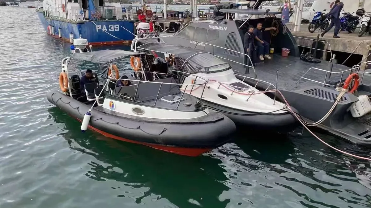 Small workboat with a black foam collar alongside a jetty with other working boats nearby.